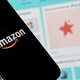 Photo of a smartphone displaying the Amazon logo in front of a screen displaying the Amazon website